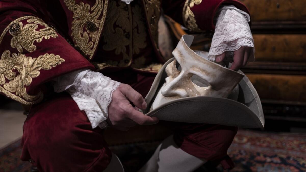 Armando Bala, owner of La Bauta Mask and Carnival Laboratory and shop holds a 'Larva' mask in 'La Bauta' shop in Venice on February 6, 2021, as the traditional Venice carnival is being cancelled due to the Covid-19 pandemic. Marco Bertorello / AFP