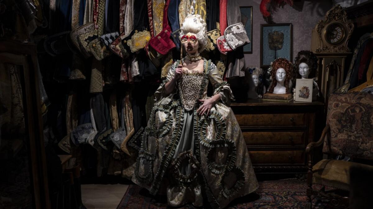 A reveller poses with a traditional carnival costume in 'La Bauta' shop in Venice on February 6, 2021, as the traditional Venice carnival is being cancelled due to the Covid-19 pandemic. Marco Bertorello / AFP