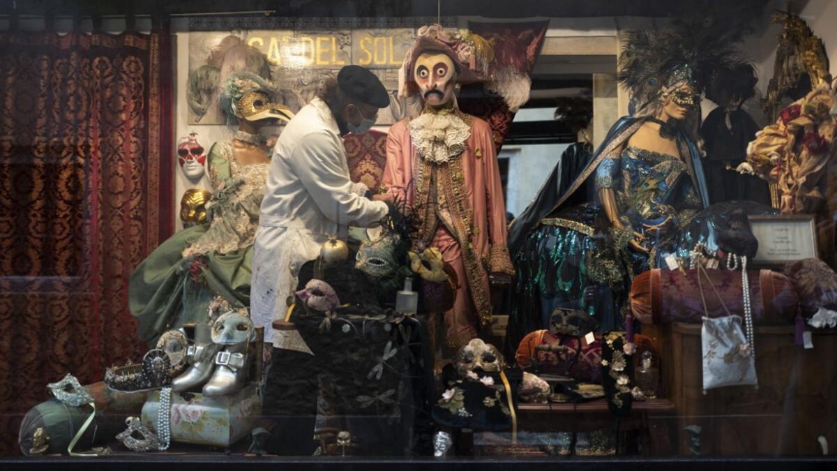 Mask artisan Hamid Seddighi sets a traditional carnival costume in the shop window of his shop and laboratory 'Ca del Sol' in Venice on February 6, 2021, as the traditional Venice carnival is being cancelled due to the Covid-19 pandemic. Marco Bertorello / AFP