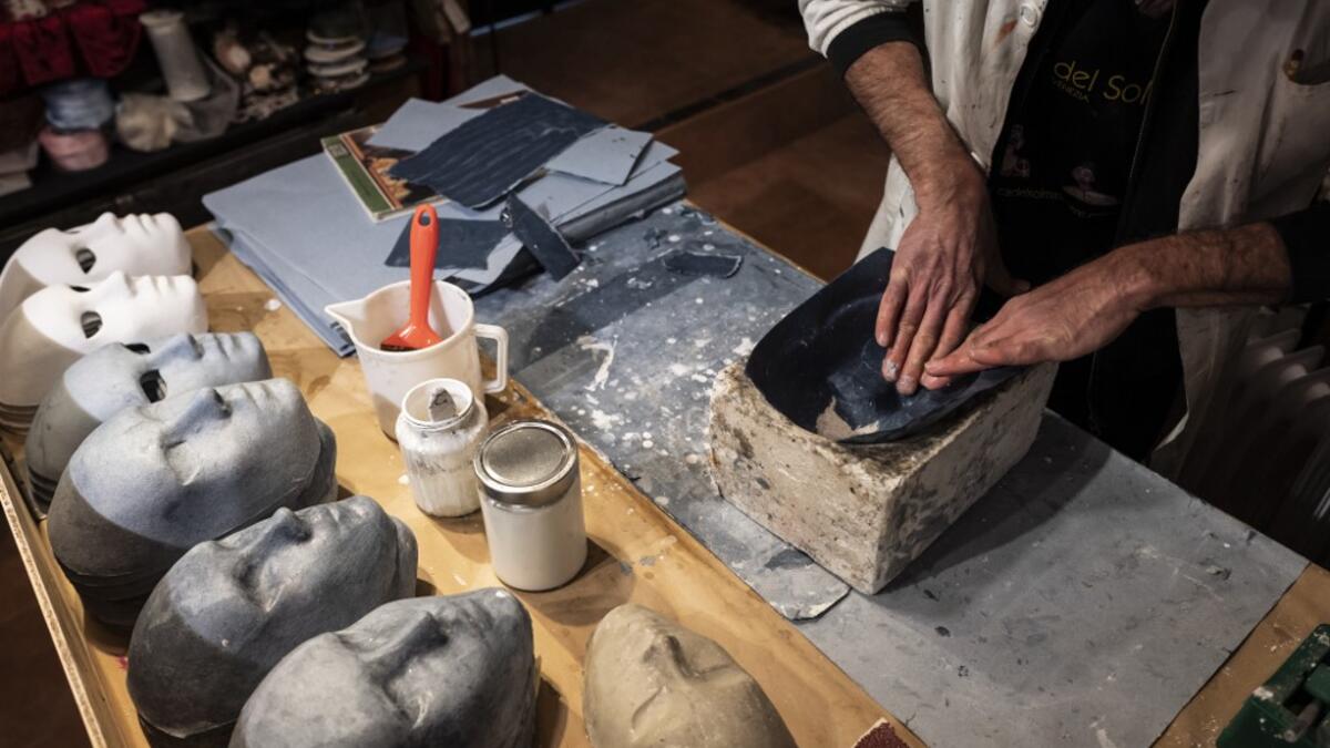 Mask artisan Hamid Seddighi works on a mask in his laboratory 'Ca del Sol' in Venice on February 6, 2021, as the traditional Venice carnival is being cancelled due to the Covid-19 pandemic. Marco Bertorello / AFP