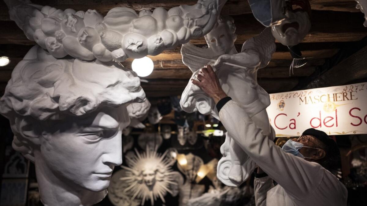 Mask artisan Hamid Seddighi adjusts a xreation in his laboratory 'Ca del Sol' in Venice on February 6, 2021, as the traditional Venice carnival is being cancelled due to the Covid-19 pandemic. Marco Bertorello / AFP