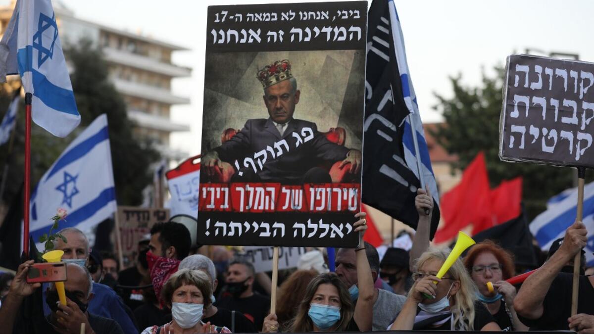 In this file photo taken on July 21, 2020, Israelis protest against Israeli Prime Minister Benjamin Netanyahu in Jerusalem. Israel's Prime Minister Benjamin Netanyahu returns to court on February 8, 2021 to formally respond to the corruption charges filed against him, as his trial enters an intensified phase six weeks before he faces re-election. Menahem KAHANA / AFP