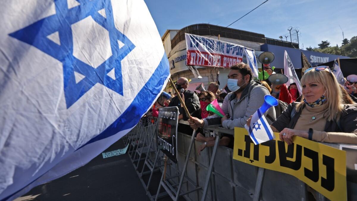 Israelis demonstrate outside the court as Prime Minister Benjamin Netanyahu's corruption trial resumes in occupied east Jerusalem, on February 8, 2021. Israel's Prime Minister Benjamin Netanyahu returns to court to formally respond to the corruption charges against him, as his trial enters an intensified phase six weeks before he faces re-election. EMMANUEL DUNAND / AFP