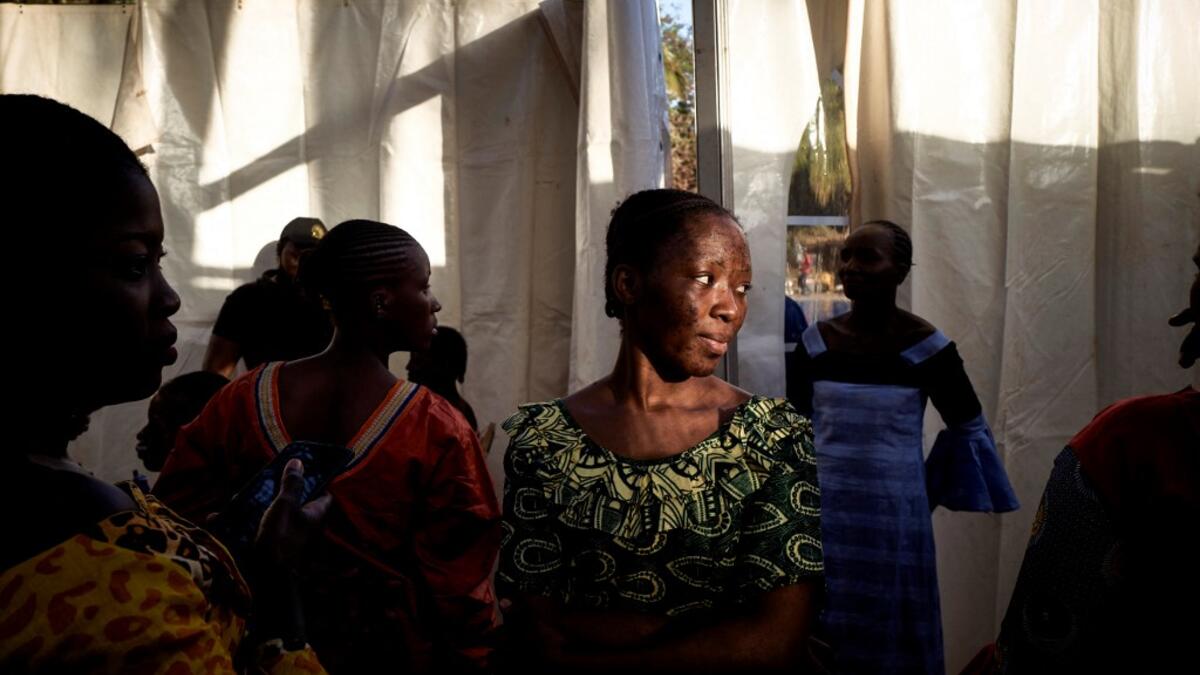 A former gold miner looks on during the first edition of the International Gold Fair Afrik'Or, in Bamako, on February 12, 2021. The Princess of Burundi, selected 34 women among gold mines workers in southern Mali, to walk down the catwalk for a fashion show organised during the International Gold Fair. Gold represents 15% of Mali's exports and more than 20% of its GDP estimated at nearly US$20 billion by the end of 2019. MICHELE CATTANI / AFP
