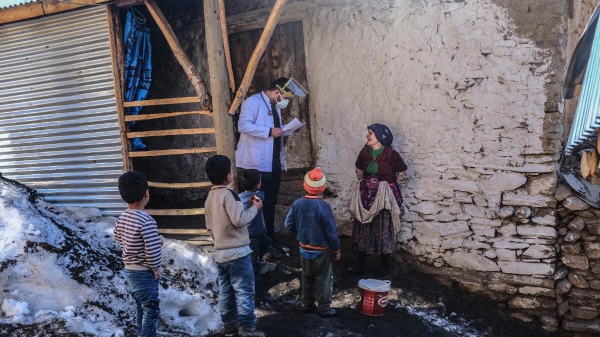 In this photograph taken on February 15, 2021, doctor Akay Kaya (L) from Bahcesaray public hospital vaccination team speaks with a Kurdish woman at the village of Guneyyamac in eastern Turkey, as part of an expedition to vaccinate residents of 65 years old or above with Sinovac's CoronaVac Covid-19 vaccine. Turkey's population of more than 83 million is spread out across Europe and Asia and covers some seemingly impregnable terrain. The vaccination effort with China's CoronaVac jab kicked off with a bang in