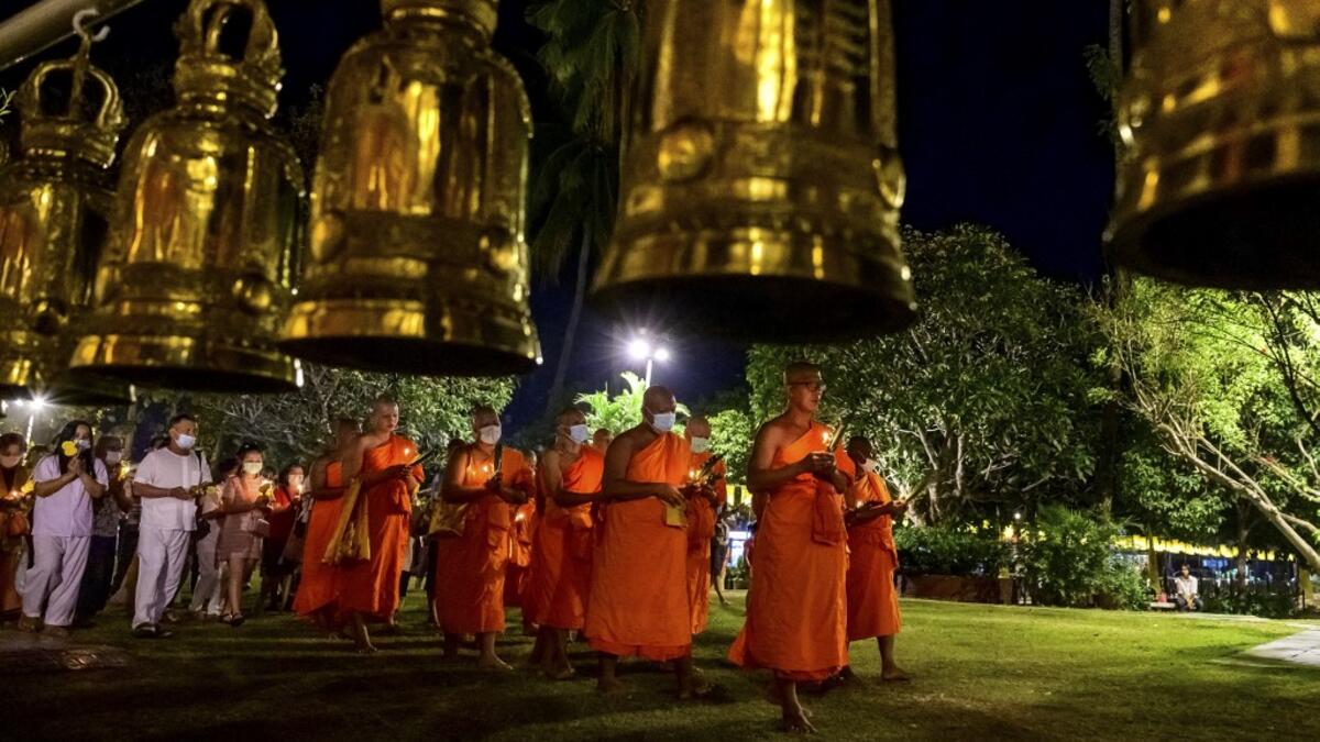 Buddhist monks lead a candlelight procession around Wat Traphang Thong to celebrate Makha Bucha Day in Sukhotai on February 26, 2021. Mladen ANTONOV / AFP