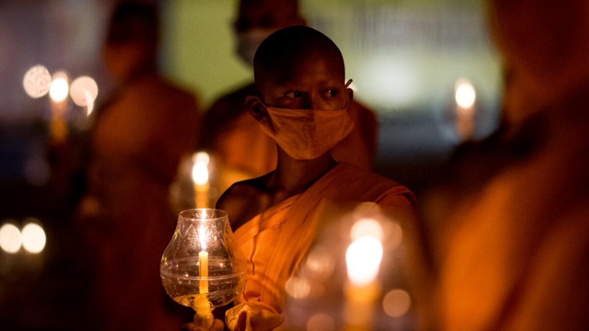 Buddhist monks hold candles during Makha Bucha celebrations at Wat Dhammakaya, north of Bangkok on February 26, 2021. Jack TAYLOR / AFP