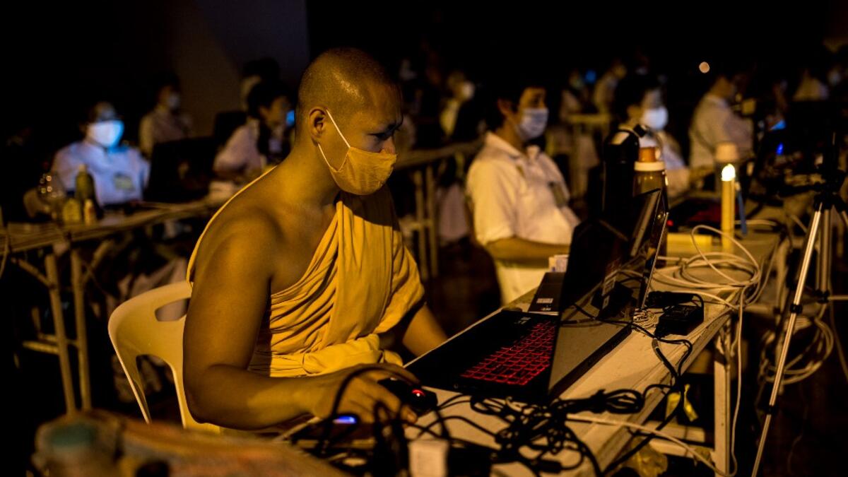 A Buddhist monk manages a video conferencing for people unable to attend Makha Bucha celebrations due to the Covid-19 coronavirus pandemic at Wat Dhammakaya, north of Bangkok on February 26, 2021. Jack TAYLOR / AFP
