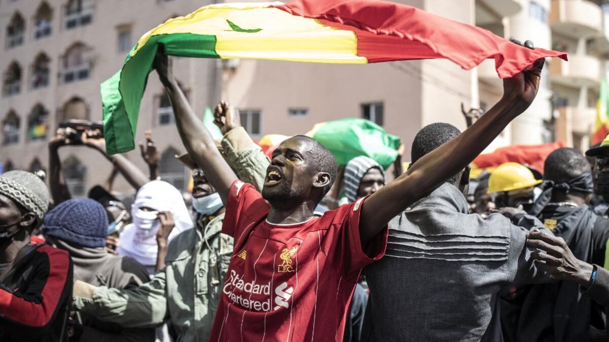 A supporter of main opposition candidate, Ousmane Sonko, reacts in protest outside the Justice Palace in Dakar on March 8, 2021. Protests have been ongoing after the Senegal opposition leader Ousmane Sonko was arrested following rape charges. JOHN WESSELS / AFP