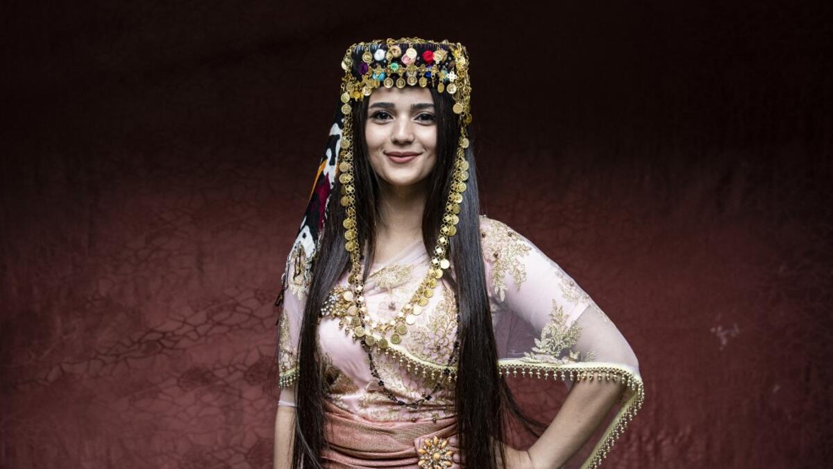 A Syrian Kurdish woman in traditional attire poses