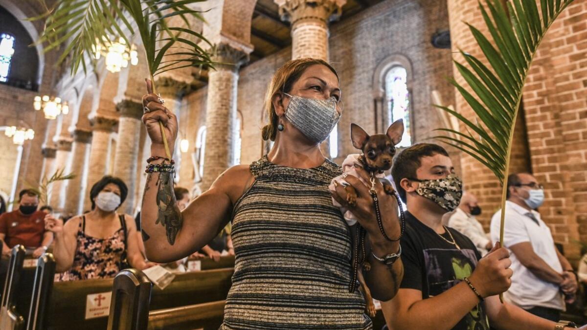 A catholic faithful holding her dog attends the traditional Palm Sunday