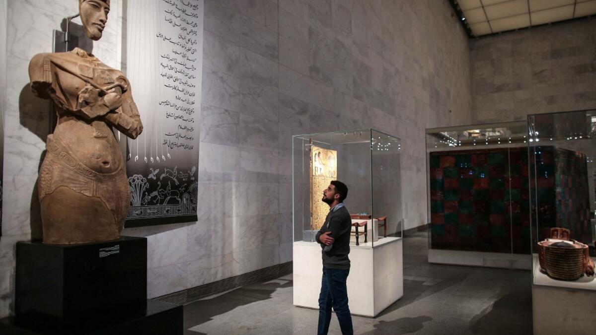 A visitor looks at a large statue of the 18th dynasty Pharaoh Akhenaten at Egypt's new National Museum of Egyptian Civilisation (NMEC)