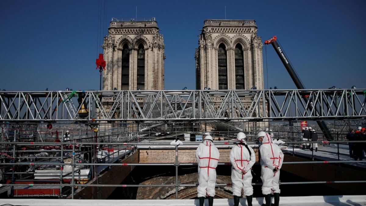 People stand on the roof of the Notre-Dame de Paris Cathedral