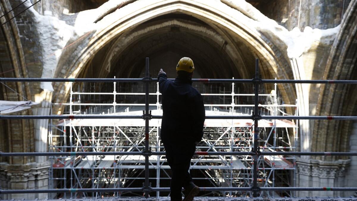 A workers looks at the vaults of the Notre-Dame de Paris Cathedral