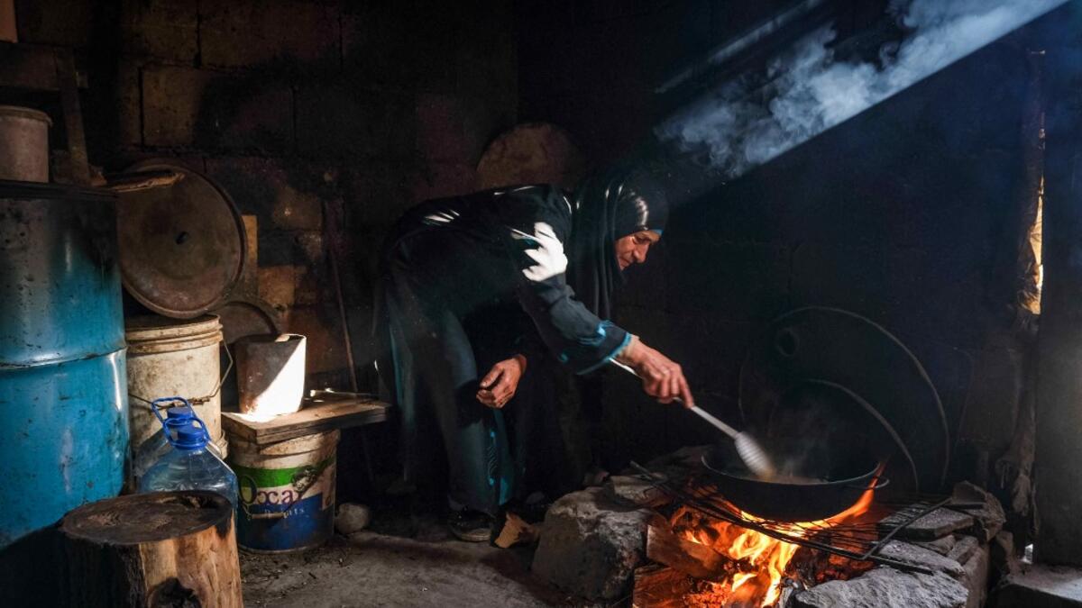 A woman fries potatoes as she prepares the fast-breaking "Iftar" meal