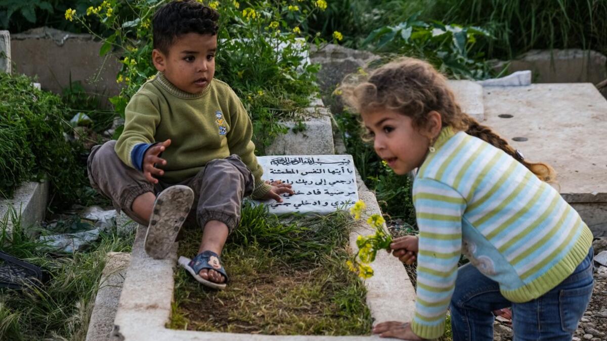 Children play by a grave in the Ghoraba (Strangers) cemetery