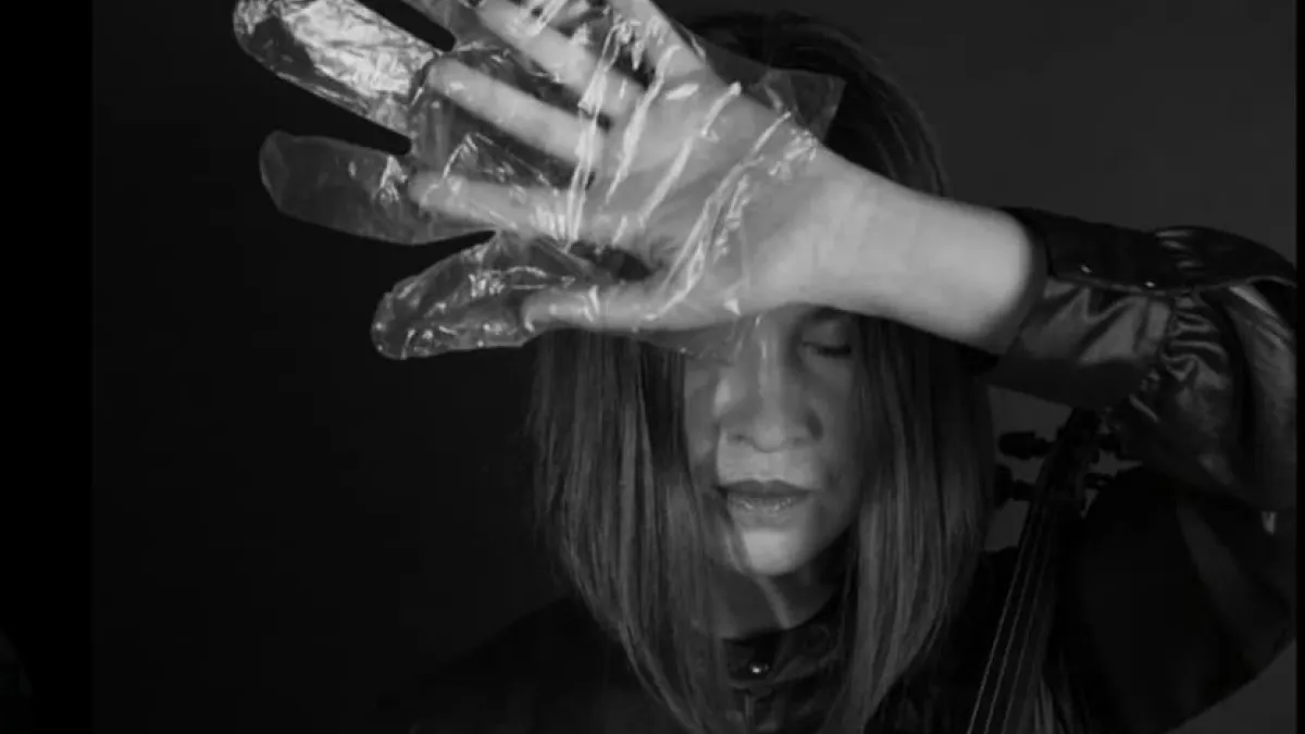 A musician in foil gloves is playing an instrument