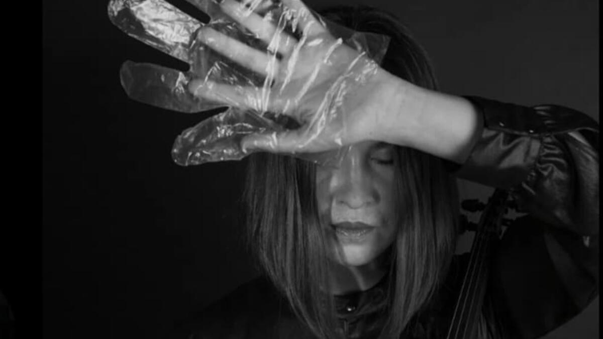 A musician in foil gloves is playing an instrument