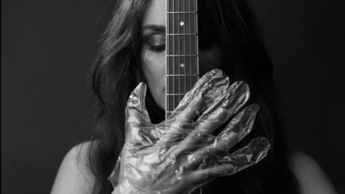 The musician in foil gloves is holding the instrument