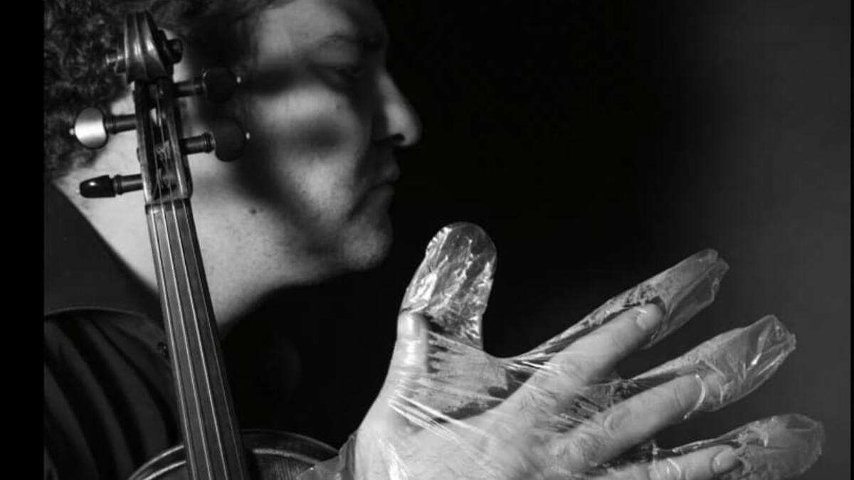 A musician in foil gloves is playing an instrument