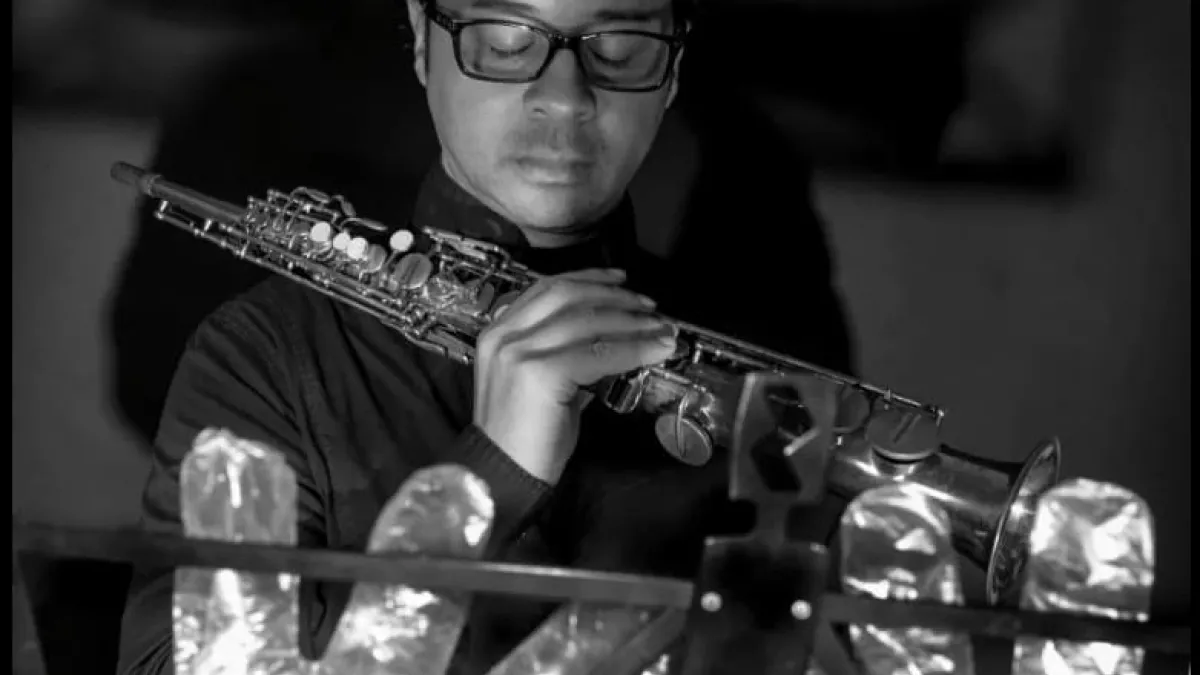 A musician in foil gloves is playing an instrument