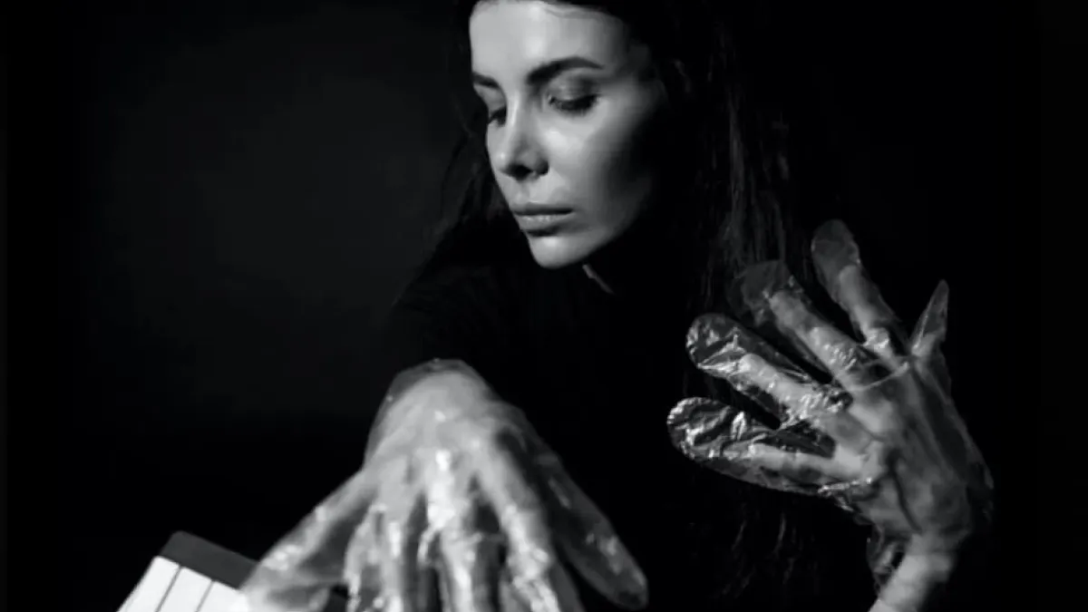A musician in foil gloves is playing an instrument