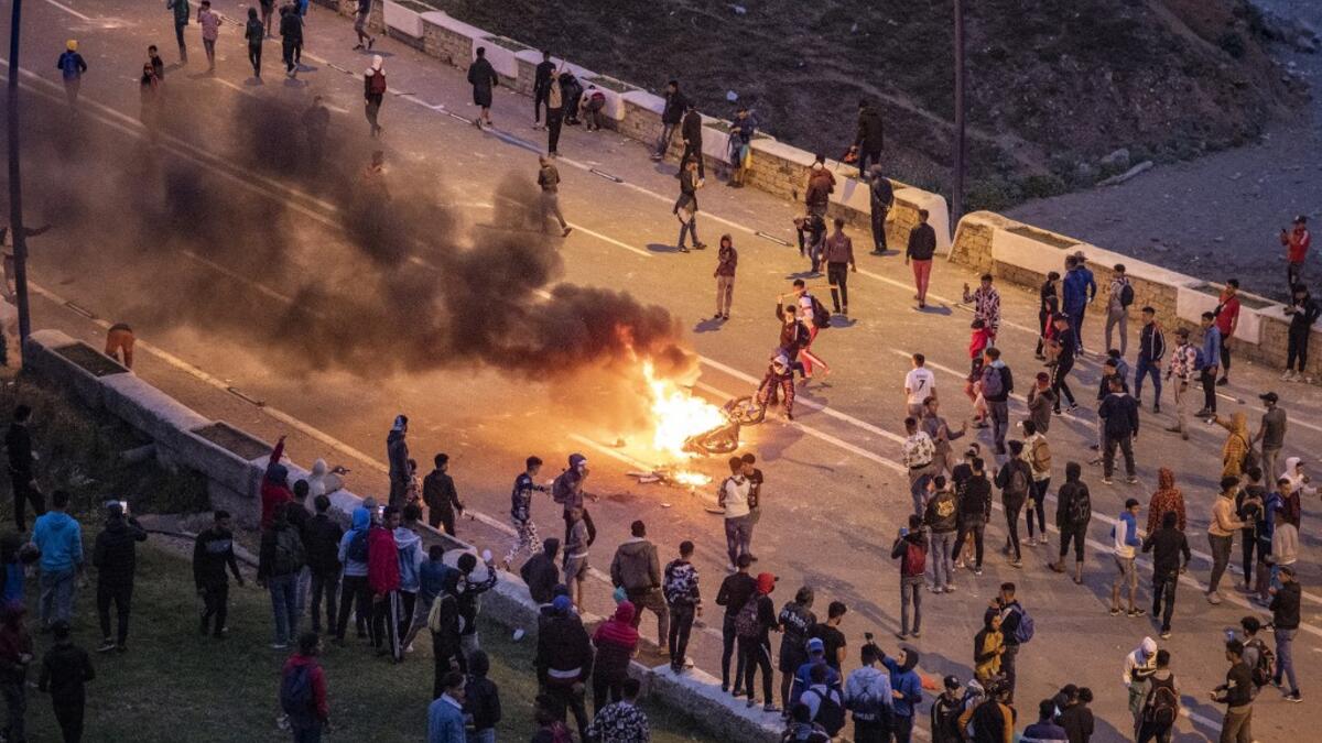 Migrants burn a motorbike as they clash with Moroccan riot police