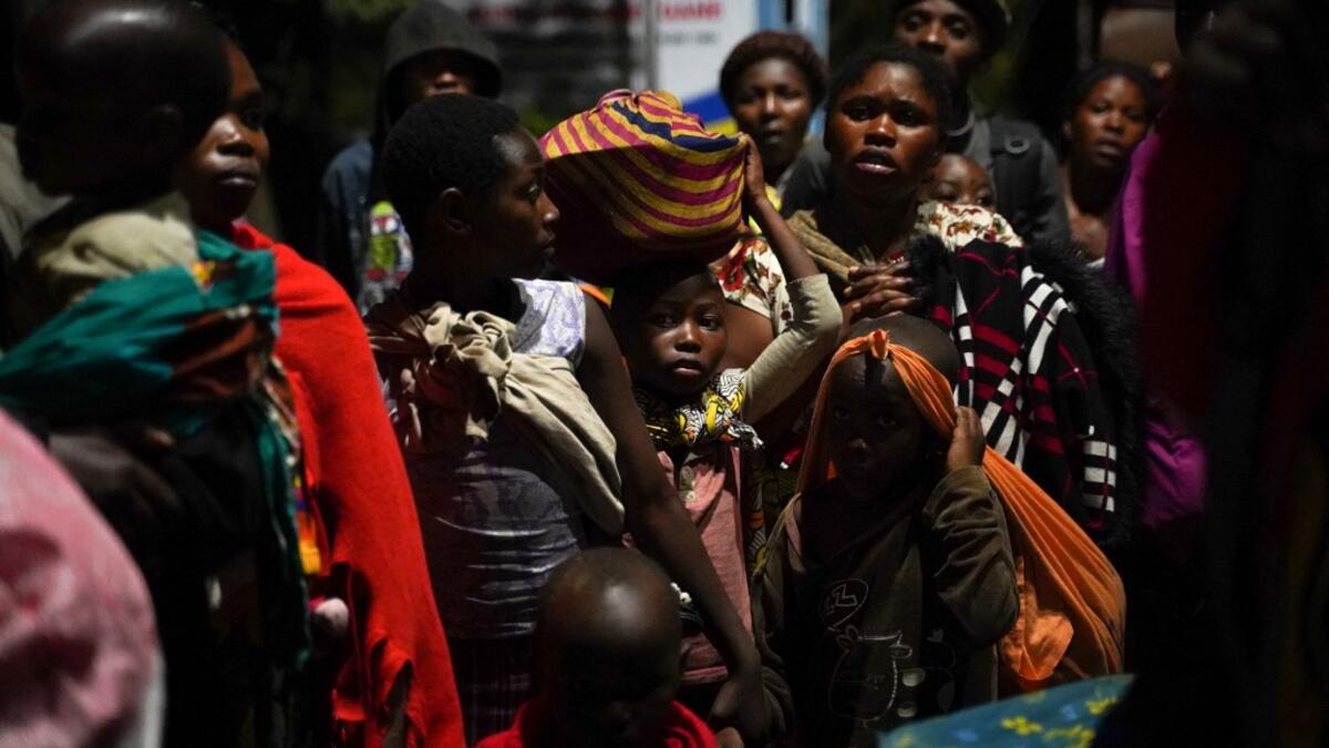 Congolese people carry their belongings as they flee from Goma, Democratic Republic of Congo (DRC), after the Nyiragongo volcano erupted, at the border point known as "Petite Barriere" in Gisenyi, Rwanda, on May 23, 2021. The government of the Democratic Republic of Congo has ordered the evacuation of the eastern city of Goma after the eruption of Mount Nyiragongo overlooking the border city. The lava reached the city's airport early Sunday, with an official from Virunga National Park