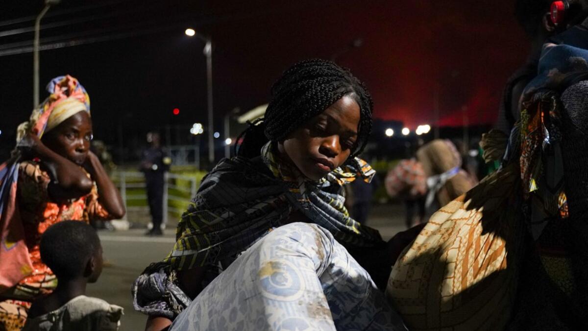 Congolese people carry their belongings as they flee from Goma, Democratic Republic of Congo (DRC), after the Nyiragongo volcano erupted, at the border point known as "Petite Barriere" in Gisenyi, Rwanda, on May 23, 2021. The government of the Democratic Republic of Congo has ordered the evacuation of the eastern city of Goma after the eruption of Mount Nyiragongo overlooking the border city. The lava reached the city's airport early Sunday, with an official from Virunga National Park