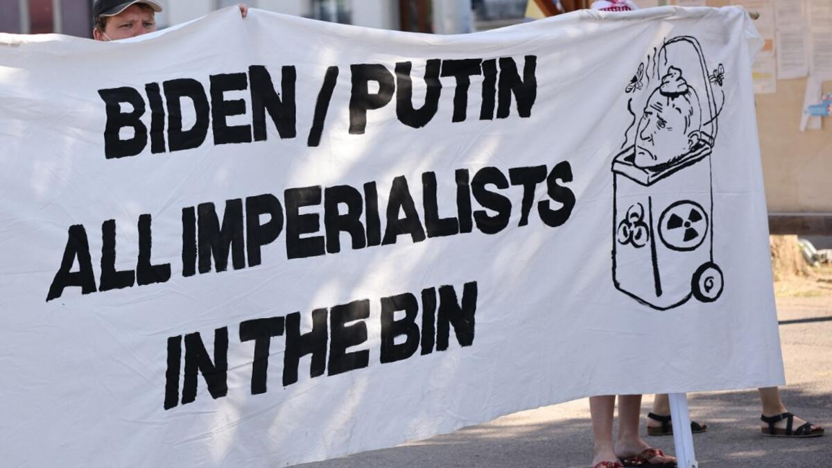 Protesters holds a banner against US and Russian Presidents during the US-Russia summit at the Villa La Grange