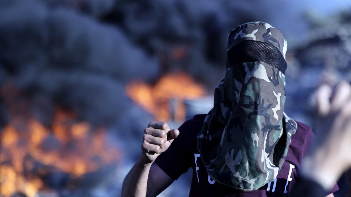 Palestinians burn tires during a night demonstration the expansion of the Jewish settlement outpost of Eviatar on the lands of Beita village, near the occupied West Bank city of Nablus