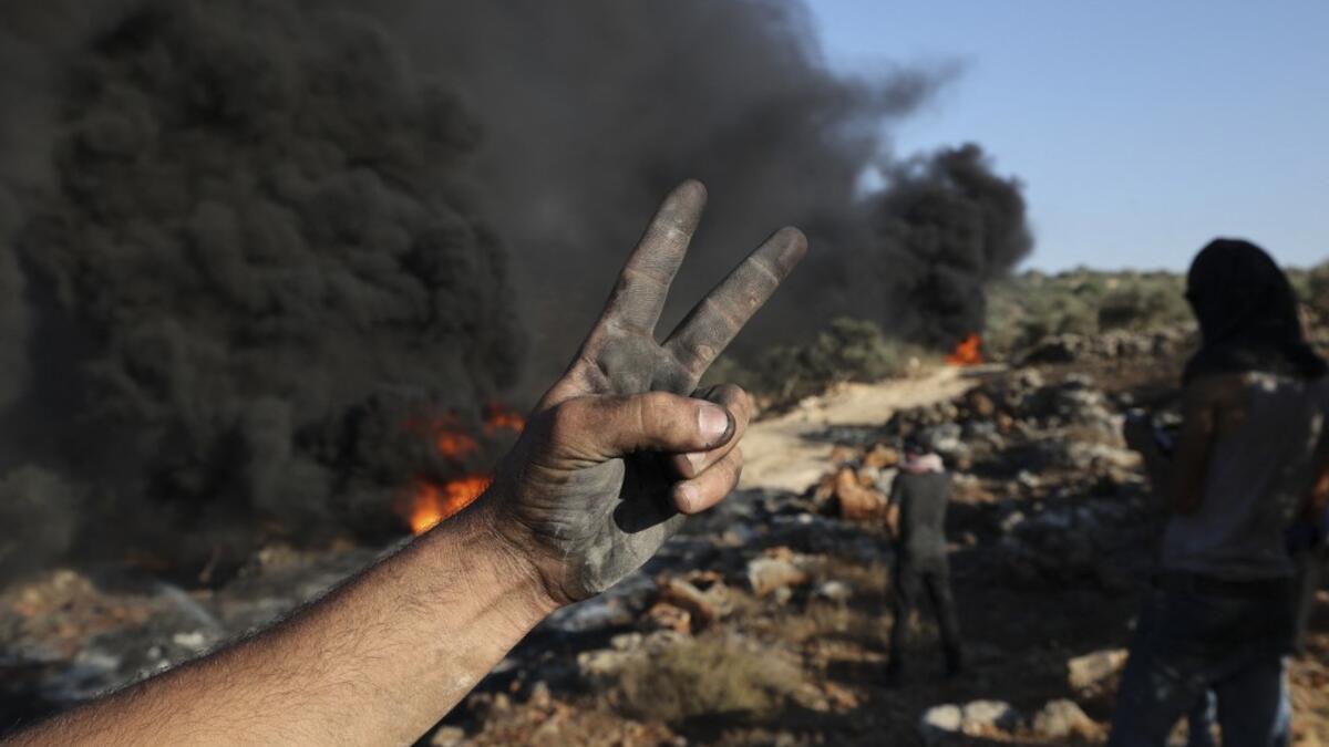 Palestinians burn tires during demonstrations against the expansion of the Jewish settlement outpost of Eviatar, on the lands of Beita village, near the occupied West Bank city of Nablus