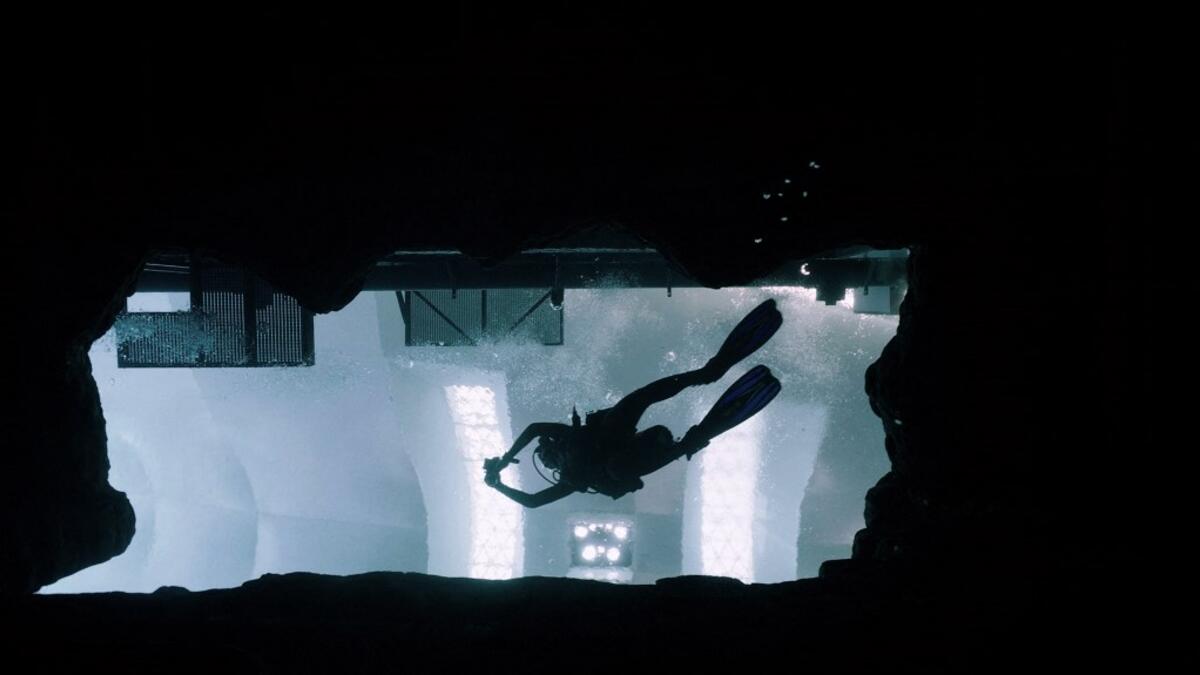 A diver experiences Deep Dive Dubai, the deepest swimming pool in the world reaching 60m, in the United Arab Emirates, on July 10, 2021. The city of superlatives, with the world's tallest tower among its many records, Dubai now has the deepest swimming pool on the planet complete with a "sunken city" for divers to explore. GIUSEPPE CACACE / AFP