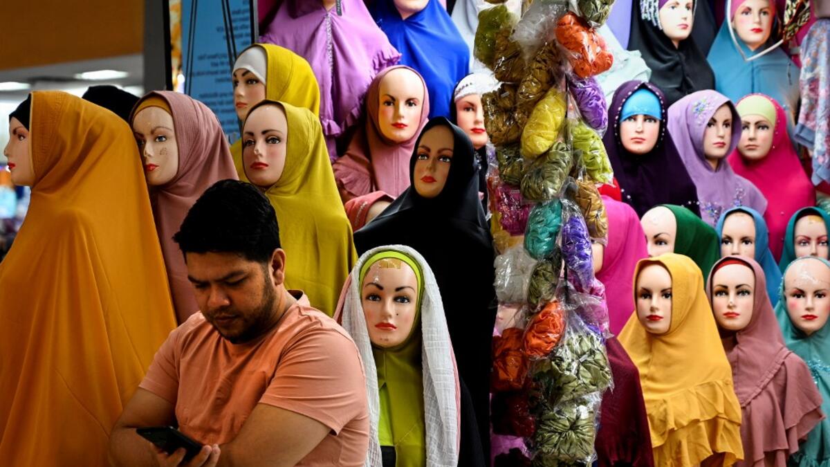 A vendor waits for customers at a shopping centre ahead of Eid al-Adha celebrations in Banda Aceh on July 17, 2021. CHAIDEER MAHYUDDIN / AFP