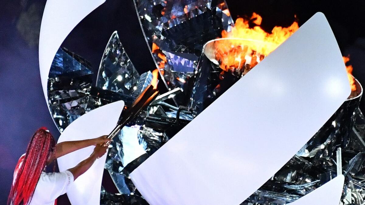 An overview shows Japan's tennis player Naomi Osaka lighting the flame of hope in the Olympic Cauldron during the opening ceremony of the Tokyo 2020 Olympic Games, at the Olympic Stadium, in Tokyo