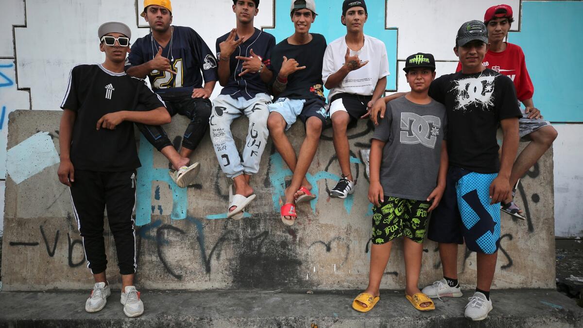 Iraqi youths pose for a picture as they gather to practice stunts on motorbikes and scooters in the Jadriya district of Baghdad on August 6, 2021. All dressed up and nowhere to go: many young Iraqis in Baghdad make an effort to be hip, even as they admit their country may have no future.