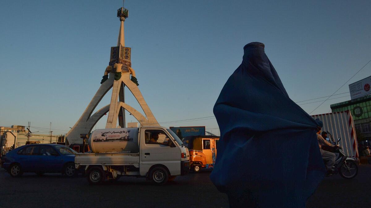 A burqa-clad woman walks along a road in Herat on September 21, 2021.