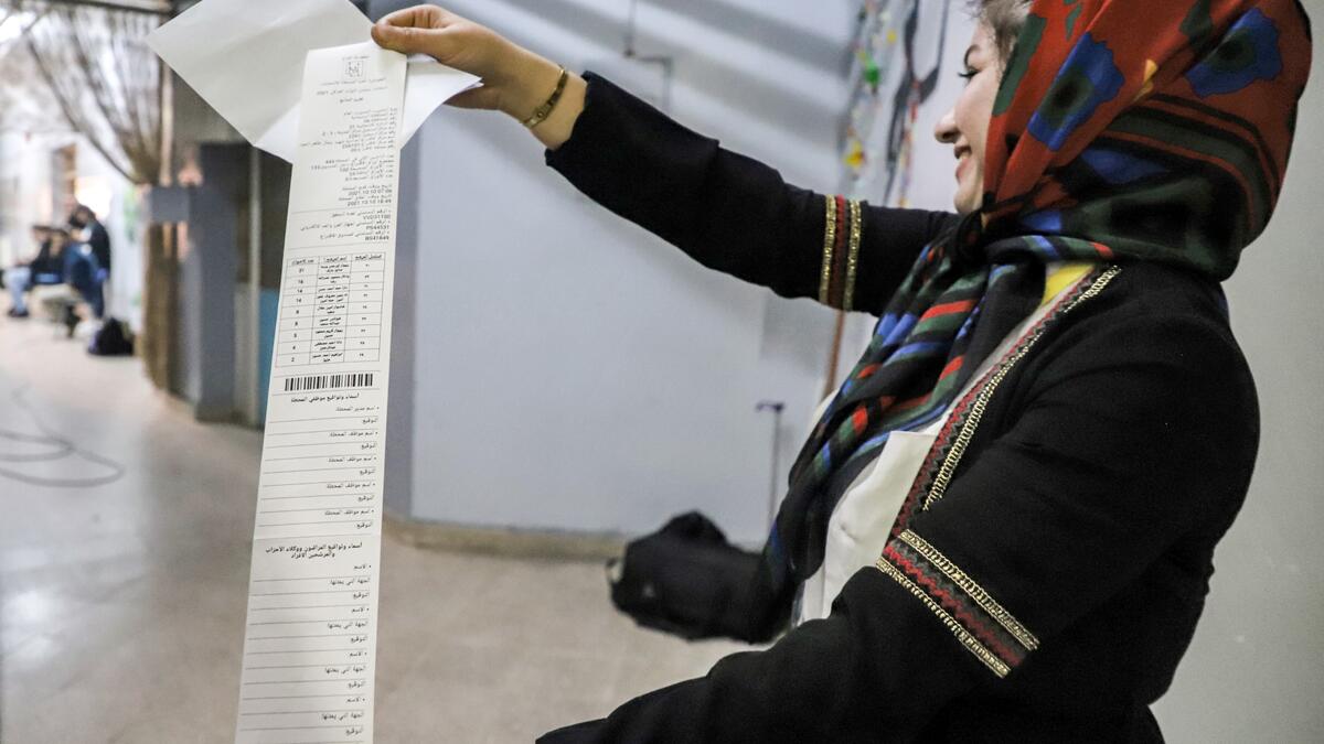 An Iraqi election official holds a printout of the electronic count of votes at a polling station in the northeastern city of Sulaymaniyah in Iraq's autonomous Kurdistan region during the early parliamentary elections on October 10, 2021. (Photo by Shwan MOHAMMED / AFP)