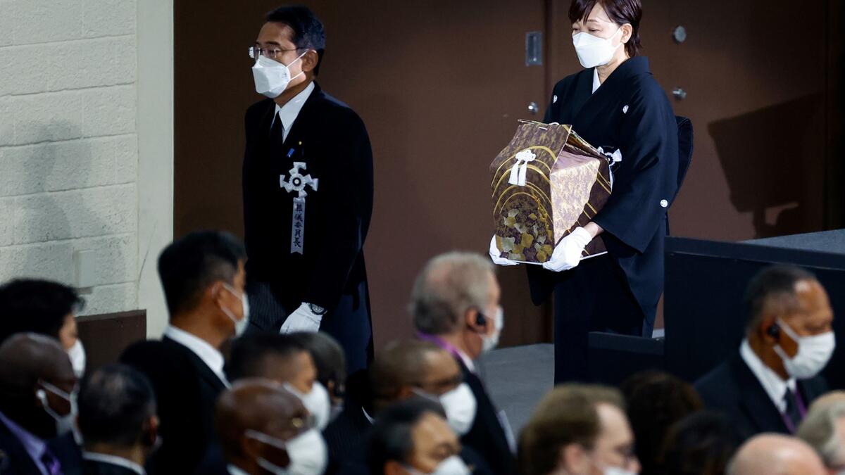 Japan's late prime minister Shinzo Abe's widow Akie Abe (R) walks behind Japan's Prime Minister Fumio Kishida as she carries her husband's ashes during his state funeral in the Nippon Budokan in Tokyo on September 27, 2022. (Photo by KIM KYUNG-HOON / POOL / AFP) Shinzo Abe