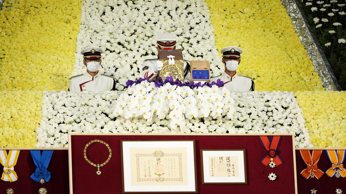 Honour guards place a cinerary urn containing the ashes of former Japanese prime minister Shinzo Abe on the altar during his state funeral in the Nippon Budokan in Tokyo on September 27, 2022. (Photo by FRANCK ROBICHON / POOL / AFP) Shinzo Abe