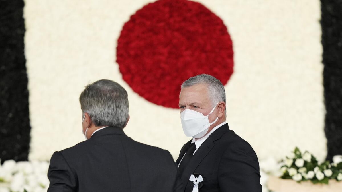Jordan's King Abdullah II (R) walks from the altar after offering flowers during the state funeral for Japan's former prime minister Shinzo Abe in the Nippon Budokan in Tokyo on September 27, 2022. (Photo by FRANCK ROBICHON / POOL / AFP) Shinzo Abe