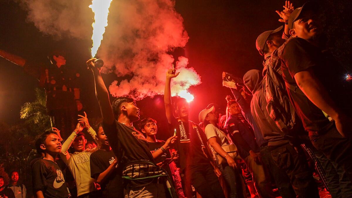 Football supporters hold candlelight vigil for victims of a stampede, in Medan on October 3, 2022. (Photo by ARIANDI / AFP) Indonesia's football stadium