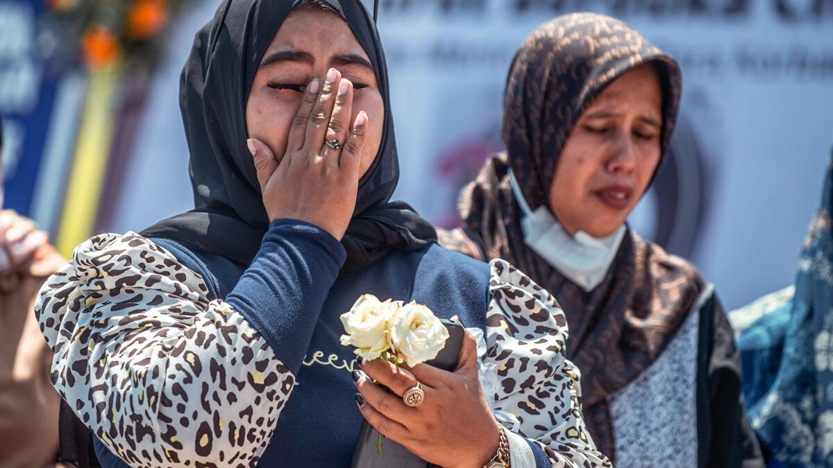 A woman reacts as people pay their respects for victims of the stampede at Kanjuruhan stadium in Malang, East Java on October 4, 2022. (Photo by JUNI KRISWANTO / AFP) Indonesia's football stadium