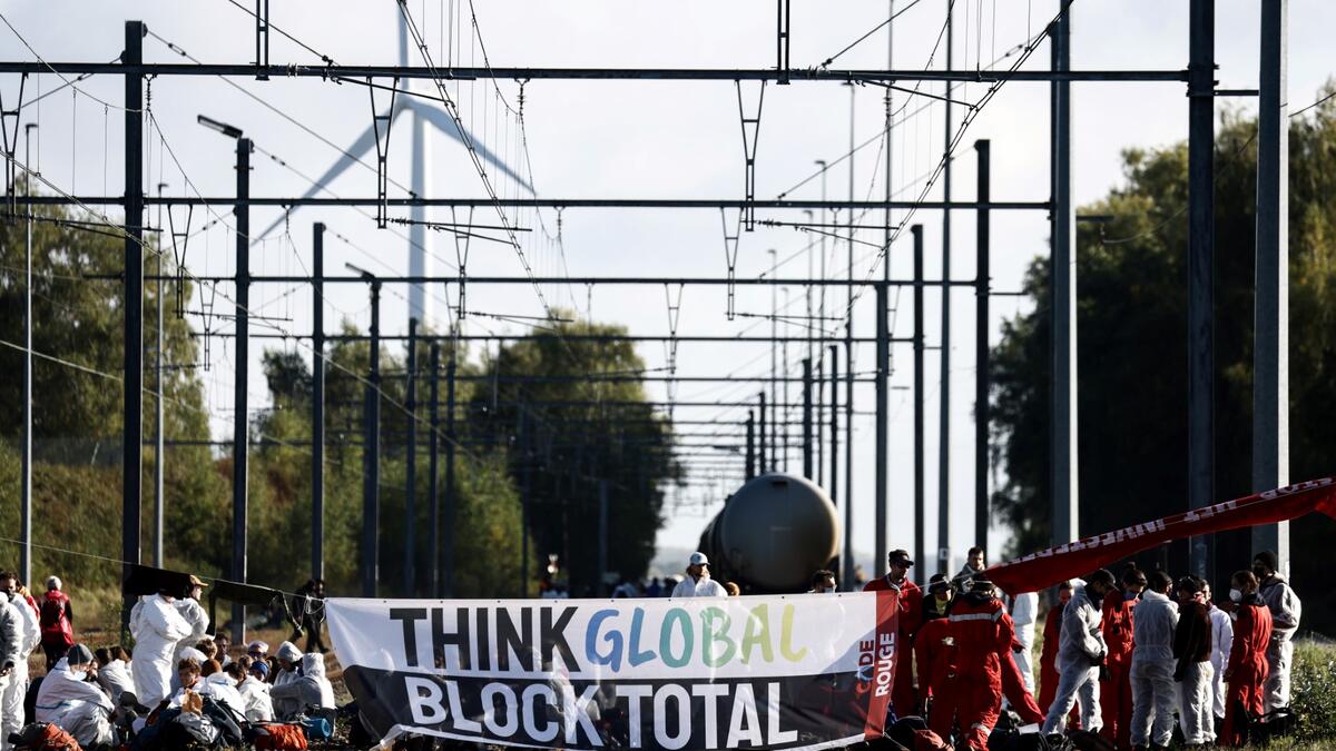 Environmental activists of the "code rouge" coalition block the entrance of the TotalEnergies Refinery in Feluy, near Brussels on October 8, 2022. (Photo by Kenzo TRIBOUILLARD / AFP) Energy crisis