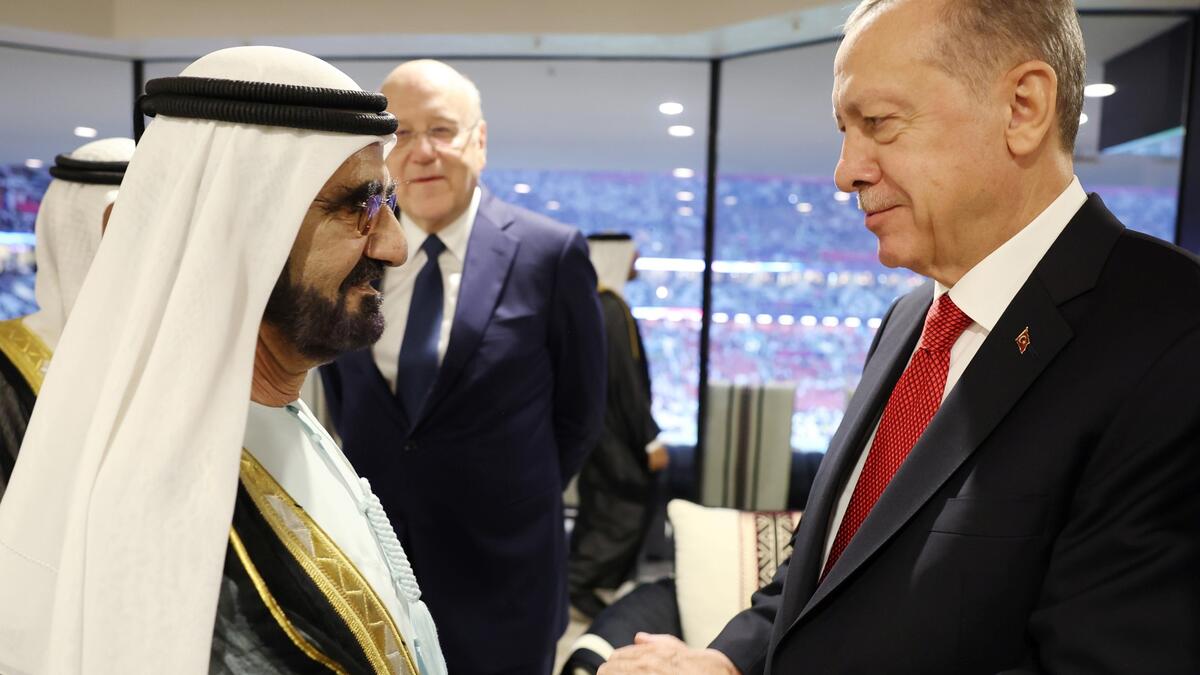 Erdogan and This handout photograph taken and released by The Press Office of the Presidency of Turkey on November 20, 2022, shows Turkish President Recep Tayyip Erdogan (R) shakes hands with Sheikh Mohammed bin Rashid al-Maktoum