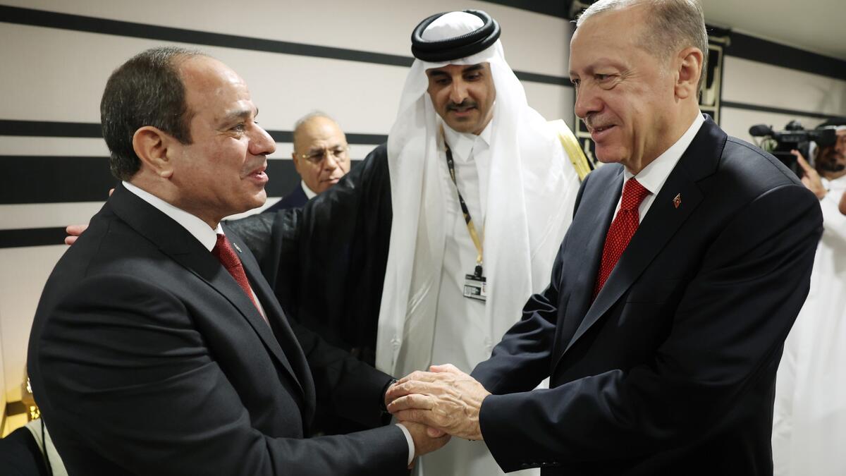 3) This handout photograph taken and released by The Press Office of the Presidency of Turkey on November 20, 2022, shows Turkish President Recep Tayyip Erdogan (R) shakes hands with Egyptian President Abdel Fattah el-Sisi as they are welcomed by Qatari Emir Sheikh Tamim bin Hamad al-Thani (2ndR)