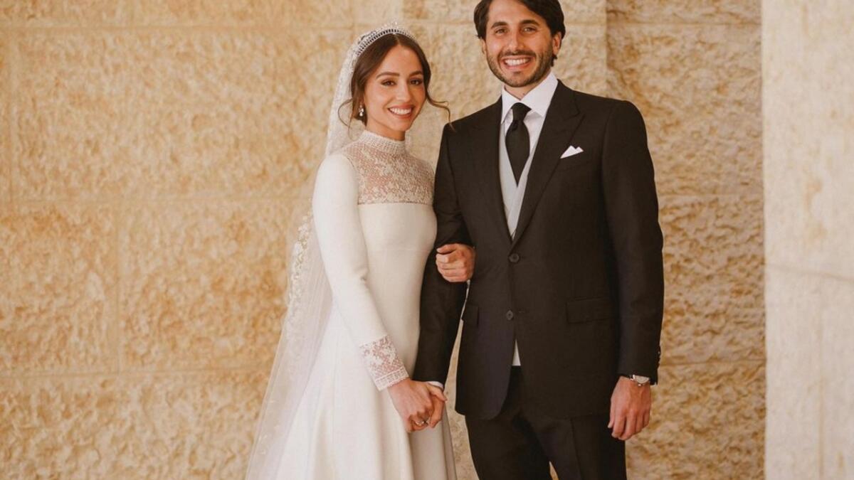 ارتدت الأميرة إيمان ثوب زفاف دانتيل بأكمام طويلة من دار ديور - Dior وتاج شوميه يقال إنه يخص جدتها الأميرة منى الحسين.