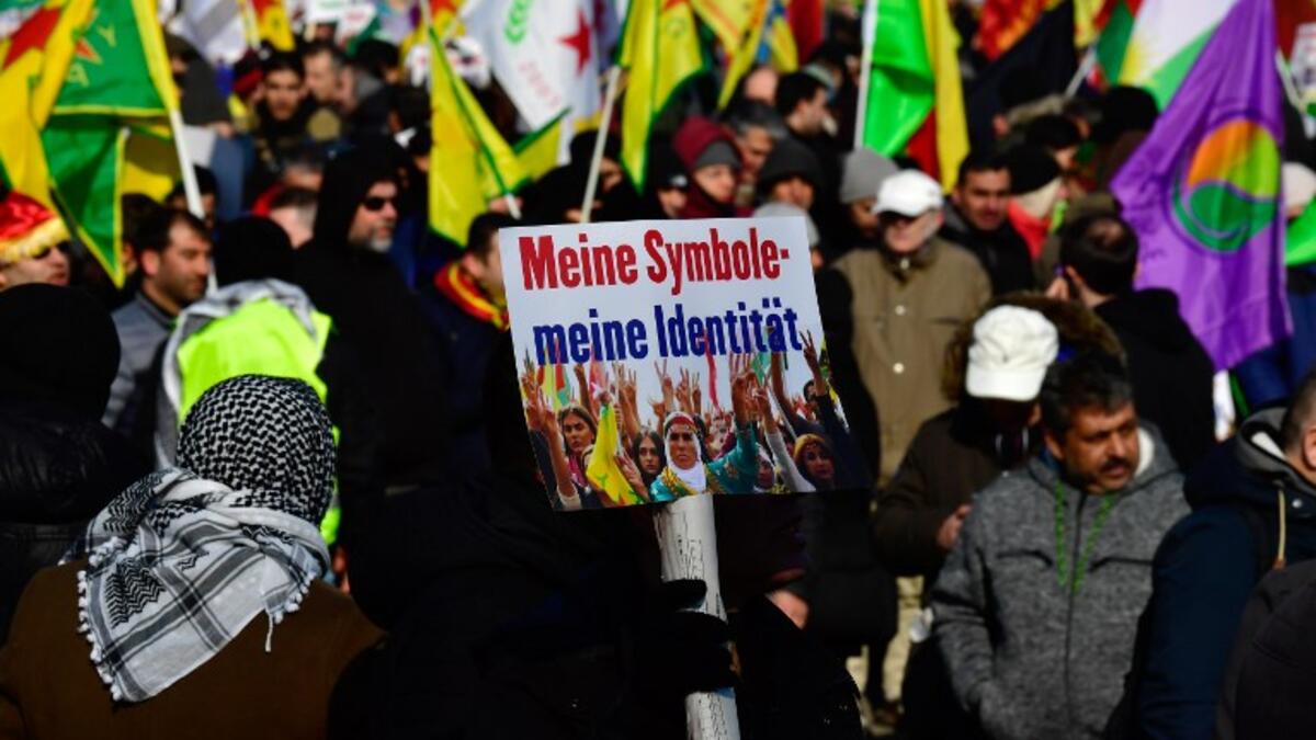 Protesters hold flags and posters reading "My symbols - my identity" during a demonstration of Kurdish groups to protest against Turkey's offensive against Kurds in Syria's Afrin region, on Mar. 3, 2018 in Berlin. 
(John MACDOUGALL / AFP)