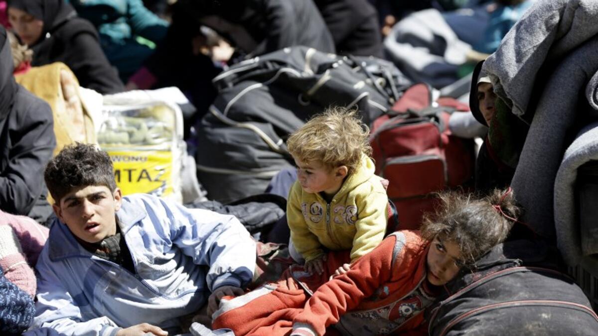 Syrian civilians, evacuated from rebel-held areas in the Eastern Ghouta, gather at a school in the regime-controlled Adra district, on the northeastern outskirts of the capital Damascus on Mar. 16, 2018. .
(LOUAI BESHARA / AFP)
