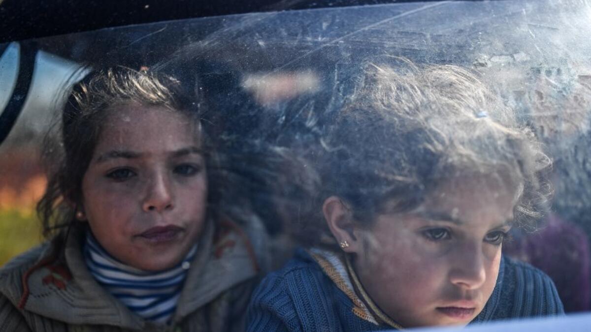 Syrian children look on as they arrive at a check point in the village of Anab ahead of crossing to the Turkish-backed Syrian rebels side on Mar. 17, 2018, as civilians flee the city of Afrin in northern Syria. (BULENT KILIC / AFP)
